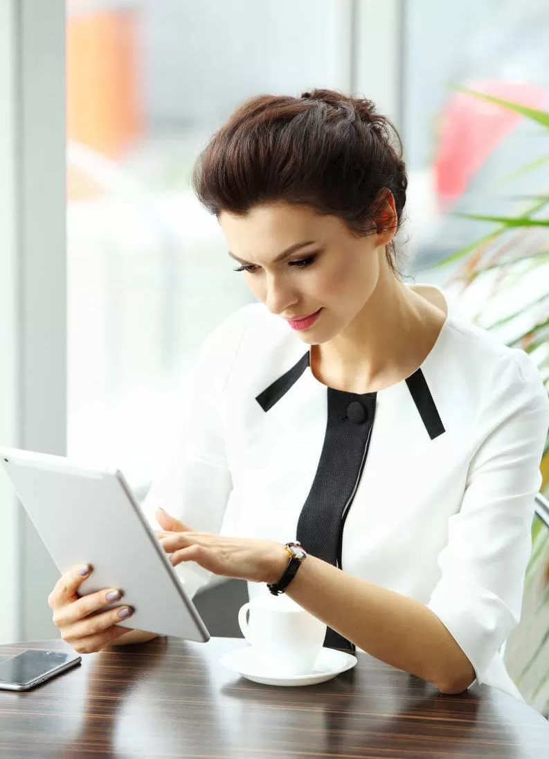 Pensive businesswoman reading an article on tablet computer Technosiga - Totvs Protheus